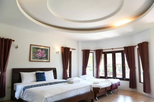 a bedroom with two beds and a round ceiling at Waterside Resort in Pran Buri