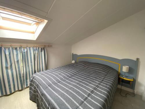 une chambre avec un lit et une fenêtre dans l'établissement Appartement en duplex avec balcon, 5 minutes plage et centre village, à La Couarde-sur-Mer