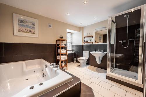 a bathroom with a tub and a shower and a toilet at Assynt House 5 Star Exclusive Use Venue in Dingwall