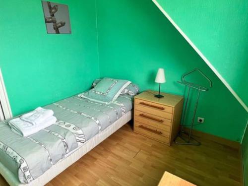 濱海莫厄朗的住宿－Attractive holiday home in Moëlan-sur-Mer with garden，一间绿色卧室,配有床和床头柜