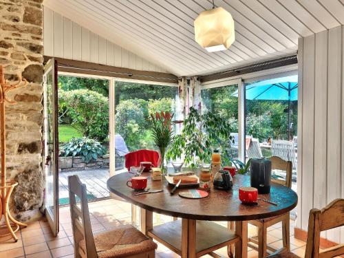 une salle à manger avec une table et des chaises sur un patio dans l'établissement Charming Stone House with Garden in Brittany, à Huelgoat