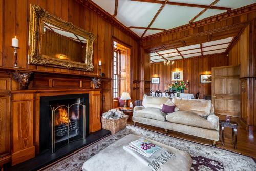 a living room with a couch and a fireplace at Assynt House 5 Star Exclusive Use Venue in Dingwall
