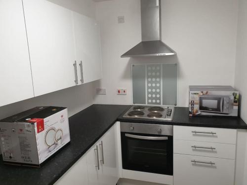 a kitchen with a stove and a box on the counter at Legends Court, Wolverhampton in Wolverhampton