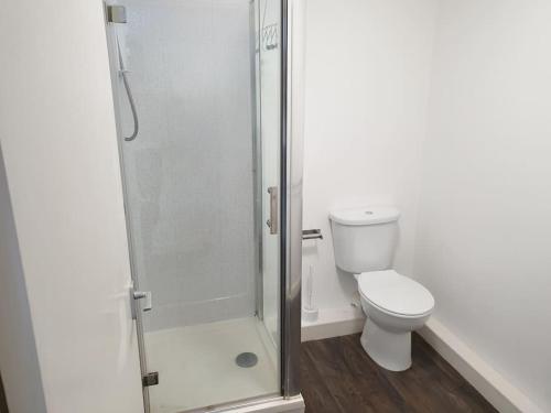a bathroom with a toilet and a glass shower at Legends Court, Wolverhampton in Wolverhampton