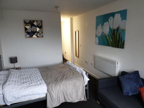 a bedroom with a bed and a couch at Legends Court, Wolverhampton in Wolverhampton