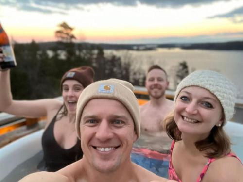een groep mensen die een bad nemen bij Archipelago villa, cabin & sauna jacuzzi with sea view, 30 minutes from Stockholm in Tyresö