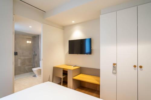a bedroom with a bathroom with a tv on the wall at Teide Rooms in Puerto de Sagunto