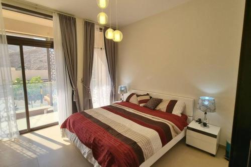 One Bedroom Apartment Muscat Bay في مسقط: غرفة نوم بسرير ونافذة كبيرة