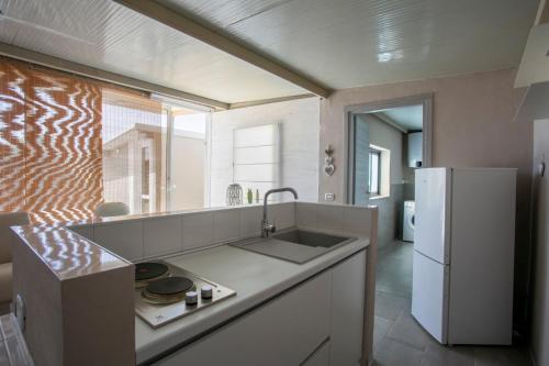 a kitchen with a sink and a refrigerator at Luxury Bungalow in Villaggio Azzurro