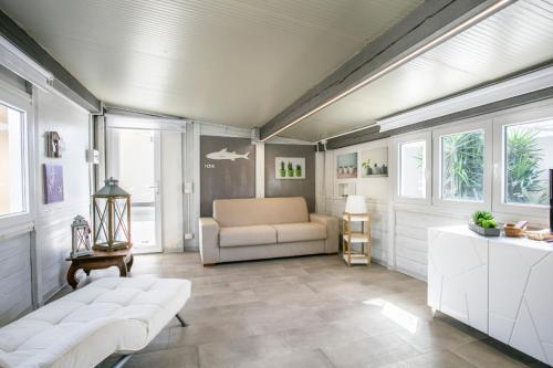 a living room with a couch and windows at Luxury Bungalow in Villaggio Azzurro