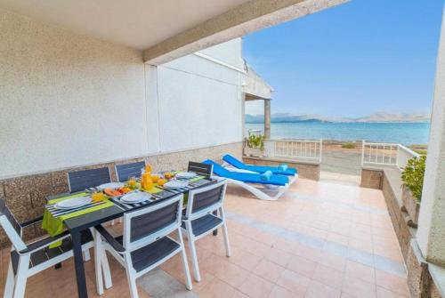 a dining room with a table and chairs and the ocean at Coastal House Sa Fortalesa in Alcudia in Alcudia