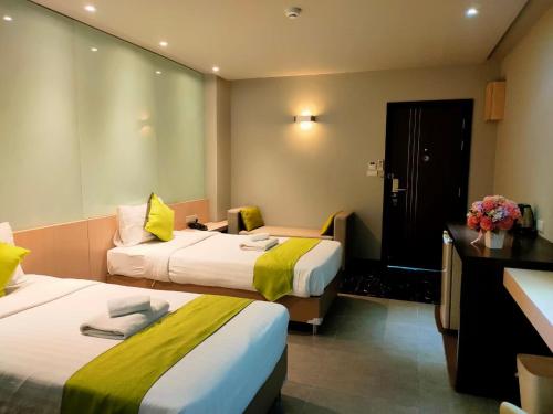 チェンマイにある3シーズンのベッド2台とデスクが備わるホテルルームです。