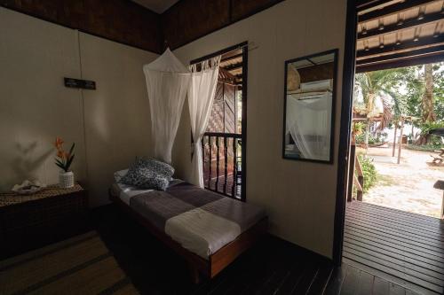 a room with a window with a bed in it at Swiss Cottage Tioman in Tioman Island