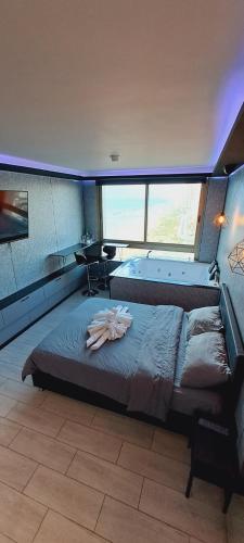 a large bed in a room with a large window at מלון כרמל/מגדל C in Netanya