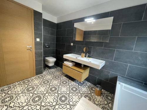 a bathroom with a sink and a toilet at Villa bellevue, neuve, 6 pax, pisc. chauffée in Brando