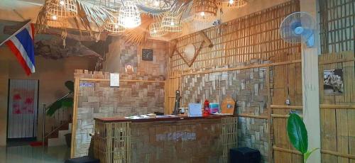 a restaurant with a counter in a room with wooden walls at Painting Family Hostel in Khao Sok