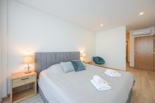1 dormitorio con 1 cama grande y 2 toallas. en Alameda 74 Luxury Apartment by Home Sweet Home Aveiro, en Aveiro