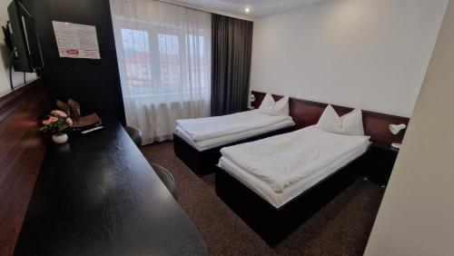a hotel room with two beds and a television at Pensiunea Stefan in Bistriţa