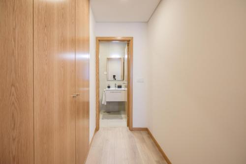 pasillo con puerta y lavabo en el baño en Alameda 74 Luxury Apartment by Home Sweet Home Aveiro, en Aveiro