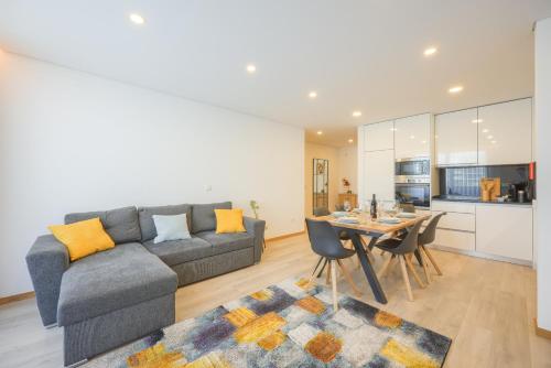 a living room with a gray couch and a table at Alameda 74 Luxury Apartment & Parking by Home Sweet Home Aveiro in Aveiro
