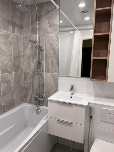 a bathroom with a tub and a sink and a shower at Prisma Apartment in Tallinn