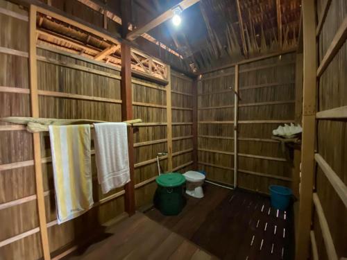 a bathroom with a toilet and towels in it at Mambetron Homestay Raja Ampat in Pulau Mansuar