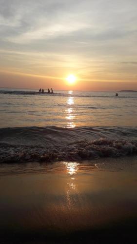 a beach with the sun setting in the ocean at The Garden House alla Scala dei Turchi in Realmonte