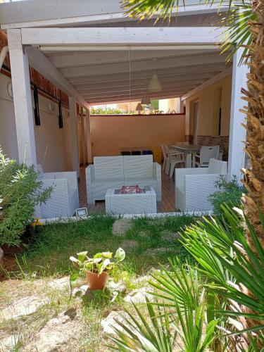 a patio with white couches and a table at The Garden House alla Scala dei Turchi in Realmonte