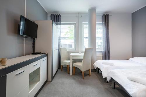 1 dormitorio con 1 cama y 1 mesa con TV en Keja Aparts - 03 Gdynia Centrum, en Gdynia