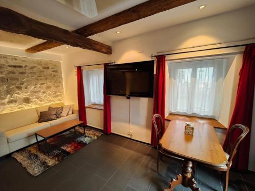 a living room with a couch and a table and a tv at Studio am Vierwaldstättersee in Horw