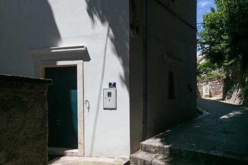 un edificio blanco con una puerta verde en una calle en Apartment Tranquilo, en Dubrovnik