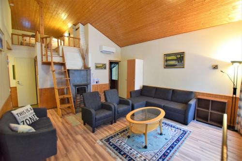 a living room with a couch and a table at Pyhtään Vuokramökit in Tuuski