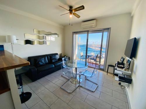 a living room with a glass table and a couch at ''Luigi'' BALCON SUR LA MER et le Port de Sète in Sète