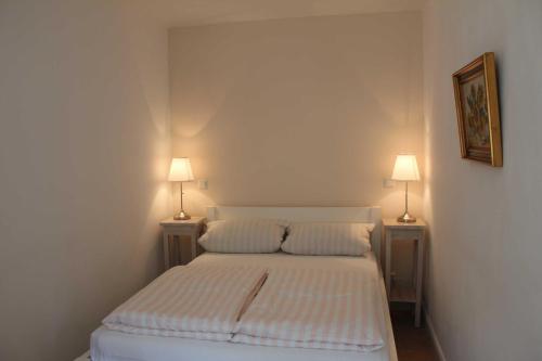 1 dormitorio con 1 cama con 2 lámparas en ambos lados en Ostseecharme, en Timmendorfer Strand