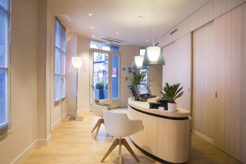 an office with a reception desk with chairs and a computer at Best Western Quartier Latin Pantheon in Paris