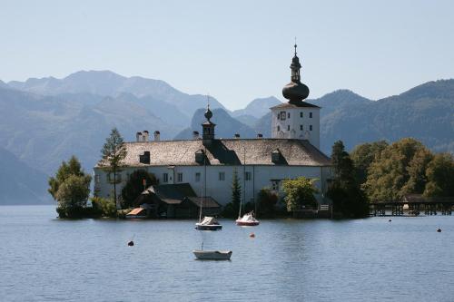 a church on an island in the middle of a lake at Haus Hepi in Obertraun