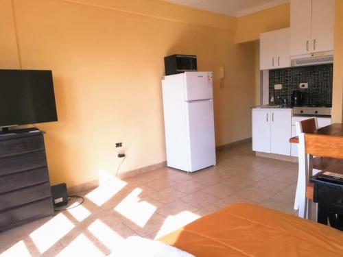 eine Küche mit einem weißen Kühlschrank und Fliesenboden in der Unterkunft Apartamentos Itati in General Sarmiento