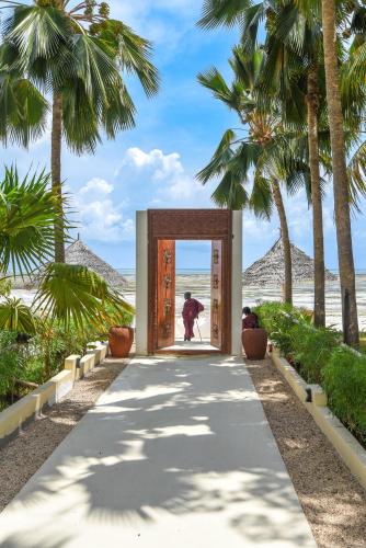 a person is standing in a doorway at the beach at Alma Boutique Hotel in Jambiani