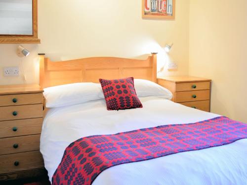 PenmachnoにあるBenar Cottages - Bwthyn Rhosynのベッドルーム1室(赤い毛布付きのベッド1台付)