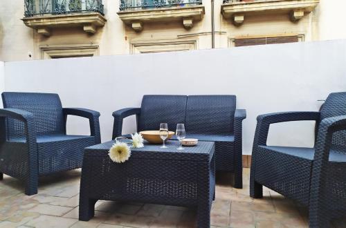 una mesa con una copa de vino y dos sillas en Ático Plaza del Salvador, en Sevilla