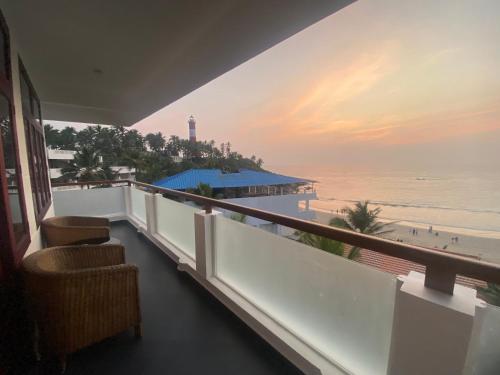 uma varanda com vista para a praia e para o oceano em Little Elephant Beach Resort em Kovalam