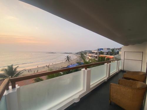 a balcony with chairs and a view of the beach at Little Elephant Beach Resort in Kovalam