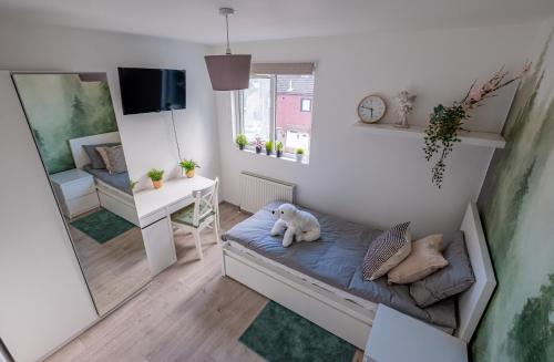 a small room with a bed with a teddy bear on it at Forest Home in Northampton