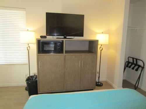 a bedroom with a flat screen tv on top of a cabinet at Carousel Beach Inn in Santa Cruz
