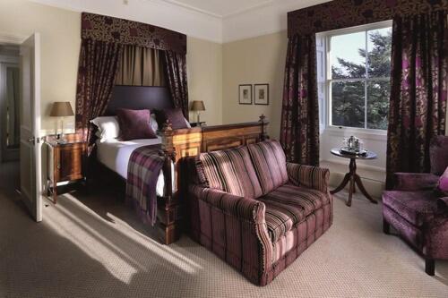 a bedroom with a bed and a couch and a chair at Macdonald Leeming House in Watermillock