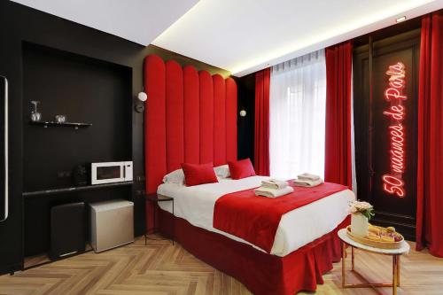 a bedroom with a large bed with red curtains at Couples Getaway Unit with Jacuzzi - City Center in Paris