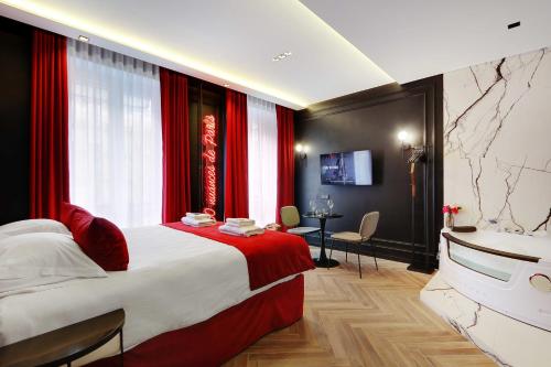 a bedroom with a large bed with red curtains and a television at Couples Getaway Unit with Jacuzzi - City Center in Paris