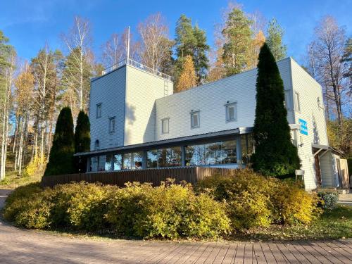 a large white house with a tree at Hostel Ukonlinna in Imatra