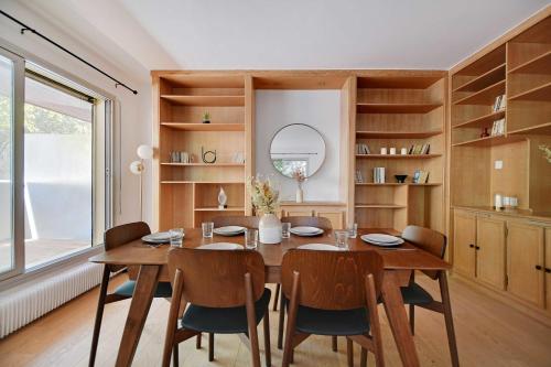 une salle à manger avec une table et des chaises en bois dans l'établissement Elegant apartment - 2BR-6P - Tour Eiffel, à Paris