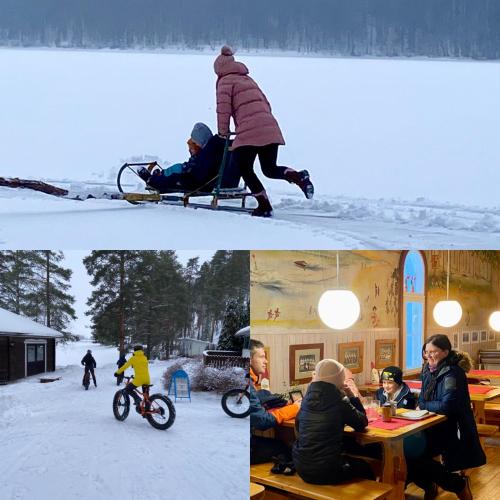a group of people sitting at a table in the snow at Hostel Ukonlinna in Imatra